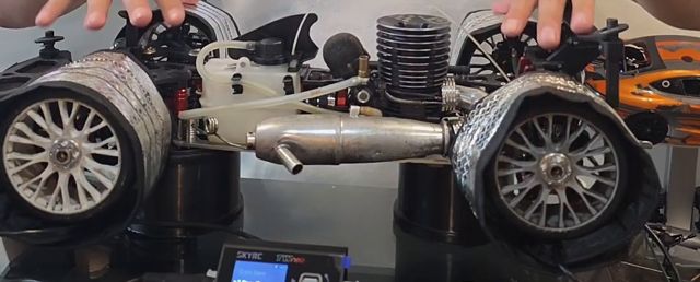 Mi coche nitro de pista con las mantas calentadoras puestas en las llantas y el SkyRC TWneo enfrente