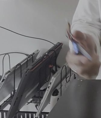 Mi mano con la pila LiPo que voy a desechar, junto a la mesa de trabajo
