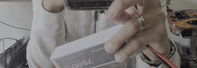 En mi mano, la pila LiPo blanca de 7800 mAh conectada al medidor de celdas